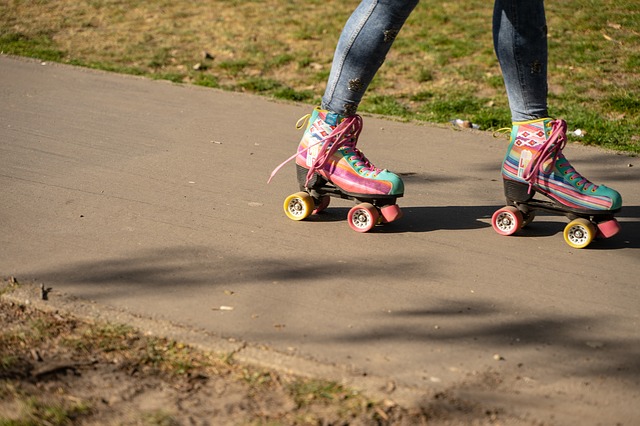 Knee down shot of person skating in colorful roller skates