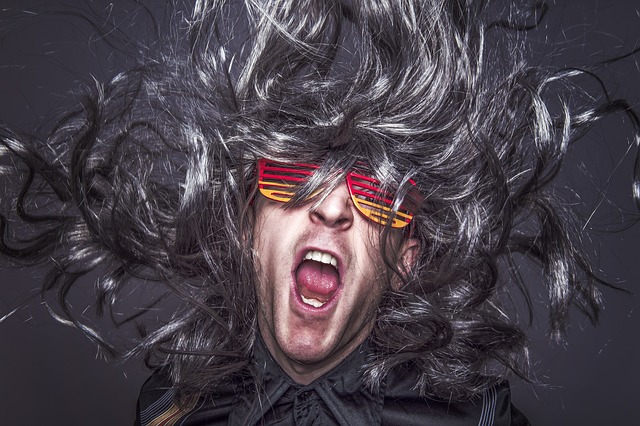 Man in wig and shutter shades costume