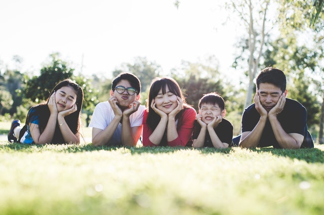 Family making silly faces on grass
