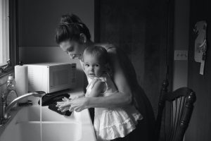 Mom helping child wash hands