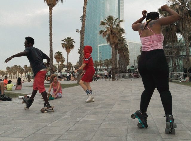 Diverse young people roller skating outside on quad skates