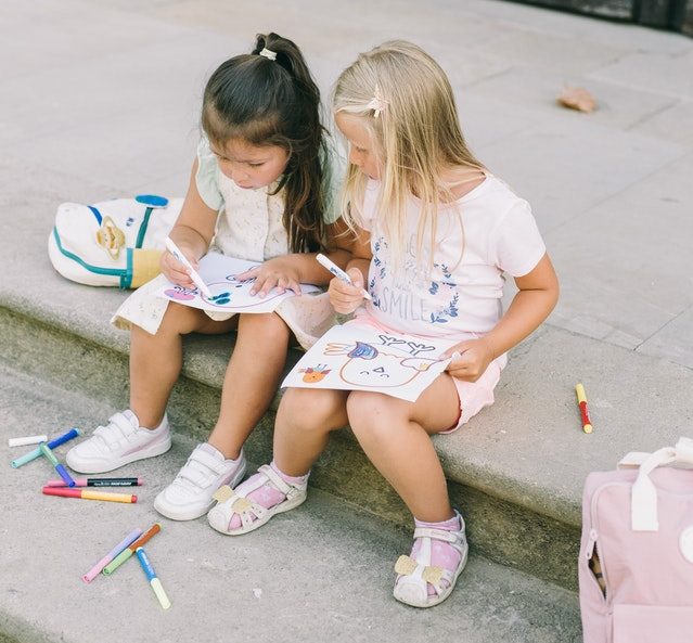 Two girls drawing outside